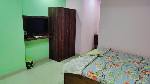 a bedroom with a bed and a wooden cabinet at BEACH STAYs in Revadanda