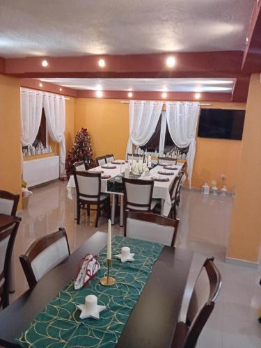 a dining room with tables and chairs and a christmas tree at CASA GRIDE in Tohanu Nou