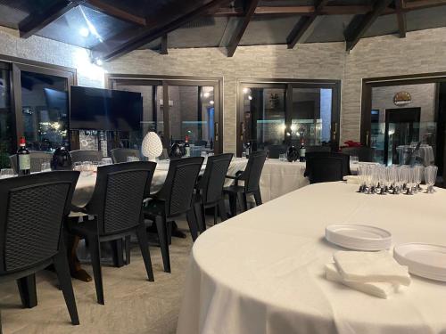 a dining room with tables and chairs and a television at B&B Etna Country in Tremestieri Etneo