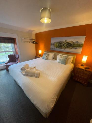 ein Schlafzimmer mit einem großen weißen Bett mit zwei Handtüchern darauf in der Unterkunft Royal Hotel in Dockray