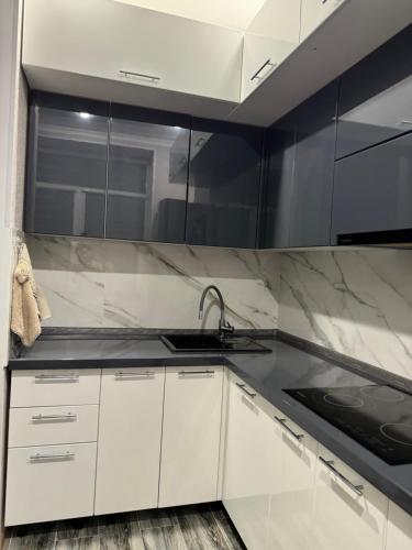 a kitchen with white cabinets and a sink at 2-ух комнатная люкс квартира in Balqash