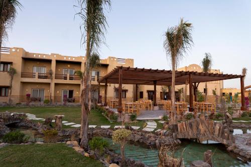 錫瓦的住宿－Siwa Sunrise Hotel，一座拥有棕榈树的大型建筑的度假村