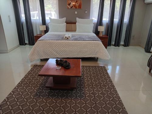 a bedroom with a large bed and a table at Nangoma Safari Lodge Lusaka in Lusaka