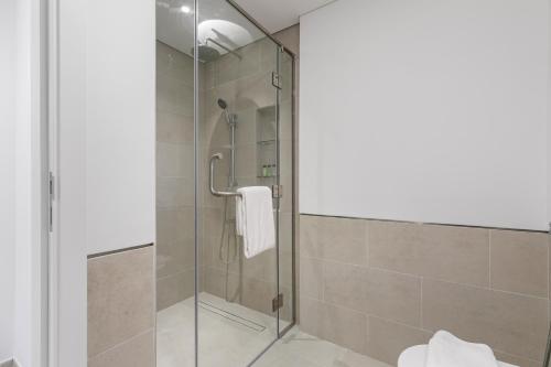 La salle de bains est pourvue d'une douche avec une porte en verre. dans l'établissement Keysplease 1 BR Apt, Madinat Jumeirah Living, à Dubaï