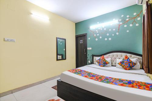 a bedroom with a bed and a blue wall at FabHotel Eco Inn in kolkata