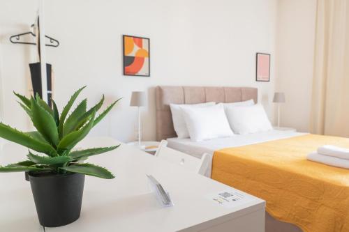 a bedroom with a bed and a potted plant on a table at Harmony Stay Center Xanthi - Meno Homes 6A in Xanthi