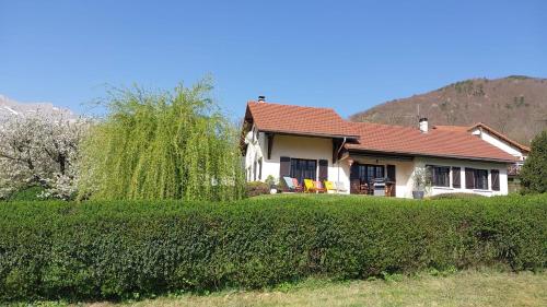 a house with a red roof and a hedge at Maison de montagne in Saint Firmin