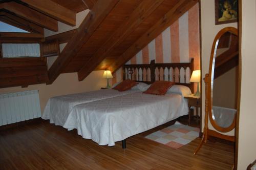 a bedroom with a large bed in a attic at HOTEL RURAL EL DENARIO in Garray