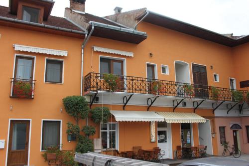 a building with a balcony and tables and chairs at Pension Ferdinand Panzio in Sfântu-Gheorghe