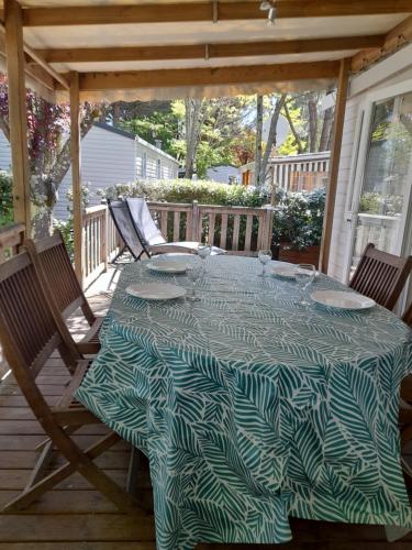 une table et des chaises sur une terrasse avec une table dans l'établissement Mobilhome spacieux MH580 3ch et grande terrasse, à Gastes