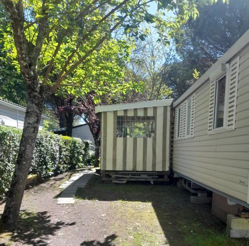 une petite maison est assise à côté d'une maison dans l'établissement Mobilhome spacieux MH580 3ch et grande terrasse, à Gastes
