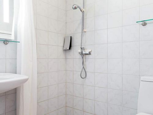 uma casa de banho com um chuveiro, um WC e um lavatório. em Holiday home Nexø XX em Neksø