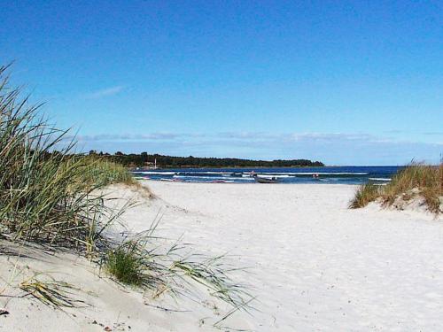 uma praia de areia com barcos na água em Holiday home Nexø XX em Neksø