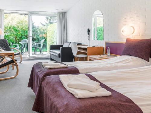 um quarto de hotel com duas camas e uma sala de estar em Holiday home Nexø XX em Neksø