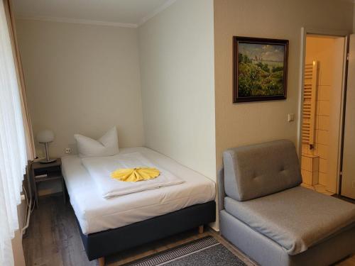 niewielka sypialnia z łóżkiem i krzesłem w obiekcie City-Hotel Cottbus w mieście Chociebuż