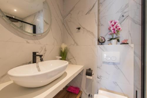 ein weißes Badezimmer mit Waschbecken und Spiegel in der Unterkunft Luxury Apartment Monika with Shared Pool in Makarska