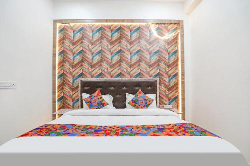 a bedroom with a bed with a colorful headboard at FabHotel Siya Bihari in Ayodhya