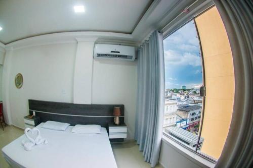 una camera da letto con un letto e una grande finestra di Temporada centro de Manaus, luxo e conforto 703 a Manaus