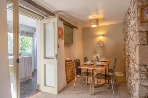 a dining room with a wooden table and chairs at L'al Cottage, Sockbridge in Penrith