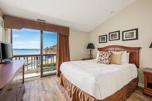 1 dormitorio con 1 cama y balcón en Stunning Lake Views at The Shores en Traverse City