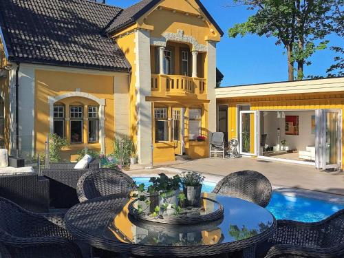 a patio with a table and chairs and a house at 10 person holiday home in arendal-By Traum in Arendal