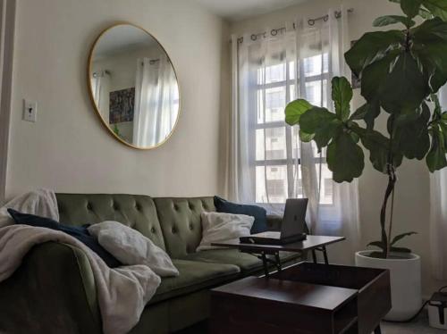 a living room with a green couch and a mirror at Apartment near Union Square in New York