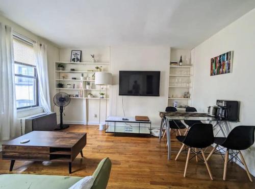 a living room with a table and a tv at Apartment near Union Square in New York