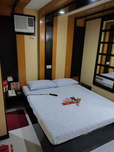 a bedroom with a bed with a remote control on it at Hotel Sogo Recto in Manila