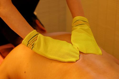 a person wearing yellow socks on a persons shoulder at Sauna & Capsule Hotel Rumor Plaza in Kyoto