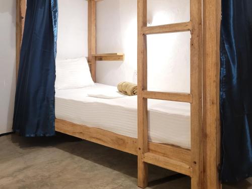 a wooden bunk bed with a ladder in a room at Agra Arugambay in Arugam Bay