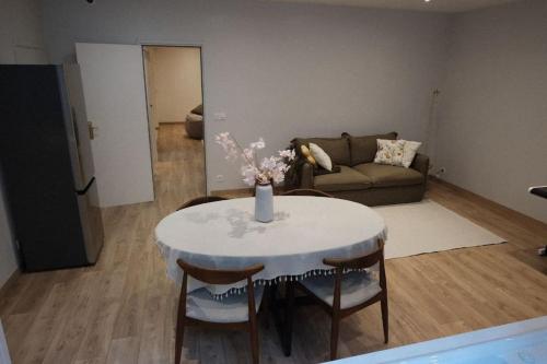 un salon avec une table avec des chaises et un canapé dans l'établissement Logement amoureux de luxe collé à PARIS, à Charenton-le-Pont