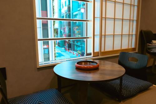 a table with a bowl on it in front of a window at 万雷ホテル in Tokyo