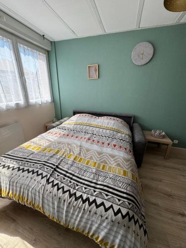 Appartement rénové tout confort, centre Valdahon في Le Valdahon: سرير في غرفة نوم مع جدار أخضر