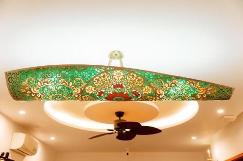 a green and gold chandelier hanging from a ceiling at 75 Garden INN in Hue