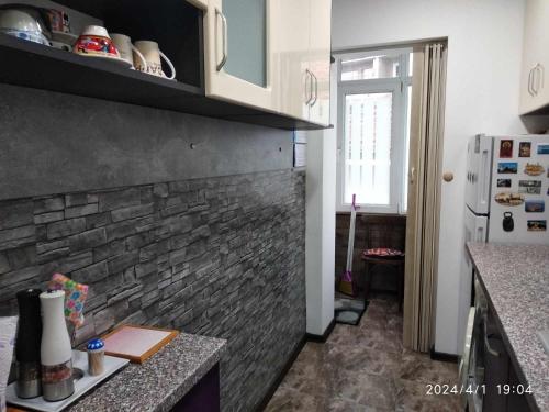 eine Küche mit Ziegelwand und Kühlschrank in der Unterkunft Деспина in Baltschik