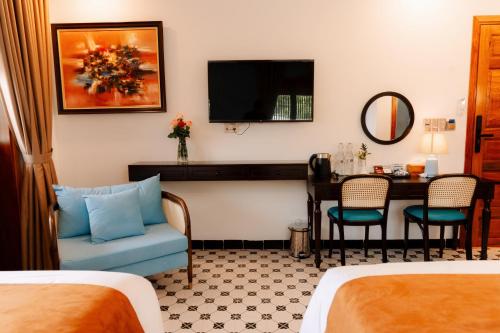 a hotel room with a bed and a table and a tv at 75 Garden INN in Hue