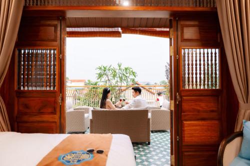 a man and woman sitting at a table in a hotel room at 75 Garden INN in Hue