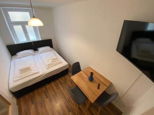 a small bedroom with a bed and a table at Nearby Trainstation Meidling in Vienna
