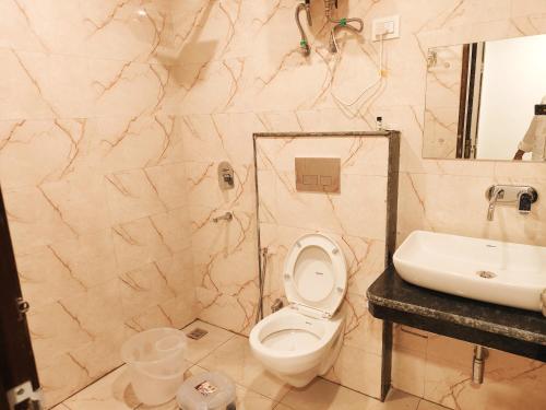 Hotel Marina Near IGI Airport Delhi في نيودلهي: حمام مع مرحاض ومغسلة