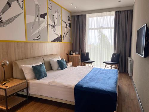 1 dormitorio con 1 cama grande con manta azul en Arena Sport Hotel en Quba