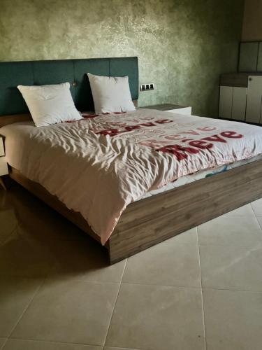 uma cama grande num quarto com uma cama grande sidx sidx em Charmante villa avec piscine DAR LUD em Chichaoua