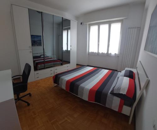 1 dormitorio con cama, silla y espejo en Camera LOW COST in alloggio condiviso Stanza 1 en Crema
