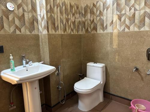 a bathroom with a toilet and a sink at Madan Kutir in Dehradun