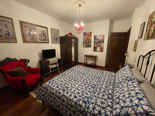 a bedroom with a bed and a red chair at B&BMagicHouse in Novara