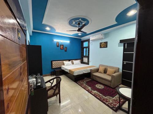 Cozy homestay Varanasi في فاراناسي: غرفة نوم بجدران زرقاء وسرير واريكة