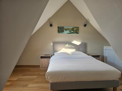 a bedroom with a large bed in the attic at Le Vinci /Maison près du château in Amboise