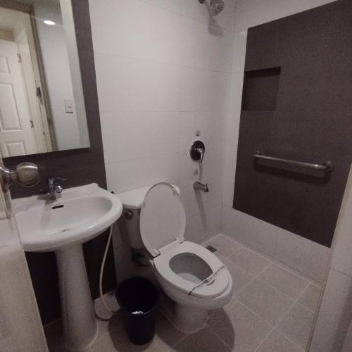 a bathroom with a toilet and a sink at Hotel Sogo - Bagong Barrio, Caloocan in Manila