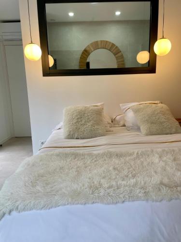 un grand lit blanc avec un grand miroir au-dessus dans l'établissement Villa récente Sanary,piscine, 3 chambres ,proche mer et centre-ville, à Sanary-sur-Mer
