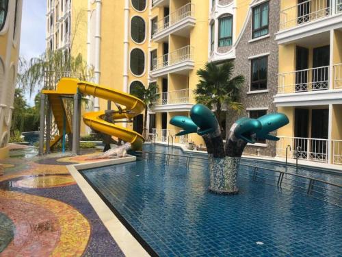 a swimming pool with a slide in a building at Espana Condo Resort By K&T in Jomtien Beach