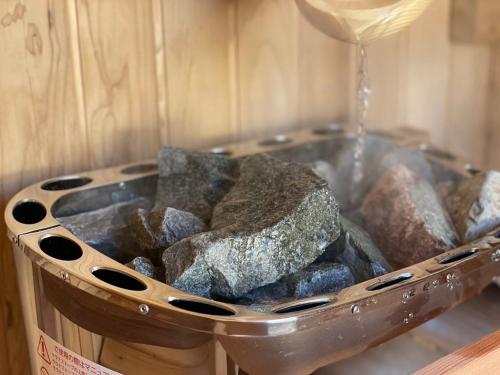 a bucket filled with rocks and a glass of wine at Tonttu 伊豆高原 in Ito